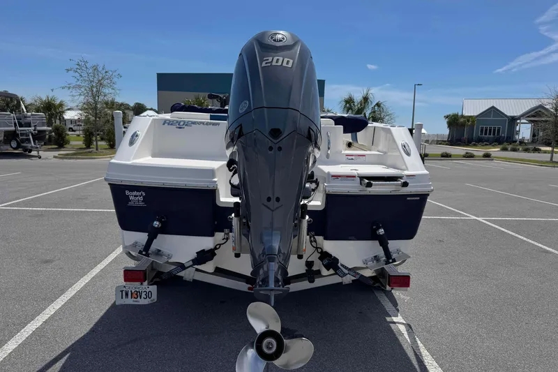 Slide: The Image of 2023 Robalo R202 Explorer boat with powerful outboard motor in parking lot. - 4
