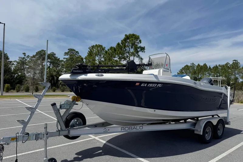Slide: The Image of 2023 Robalo R202 Explorer boat on trailer in parking lot, clear sky background. - 7