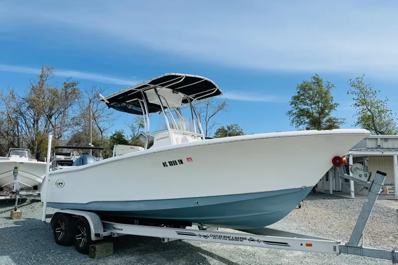 Slide: The Image of 2022 Sea Hunt Ultra 234 boat on trailer, parked outdoors under clear sky. - 1