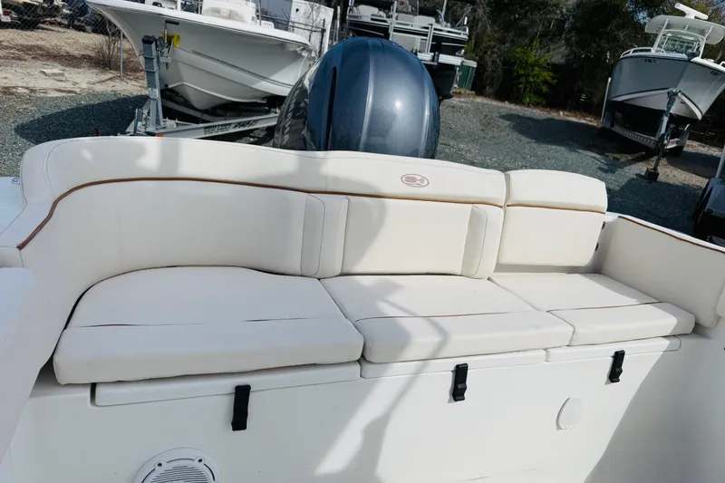 Slide: The Image of 2022 Sea Hunt Ultra 234 boat with white cushioned seating and outboard motor. - 4