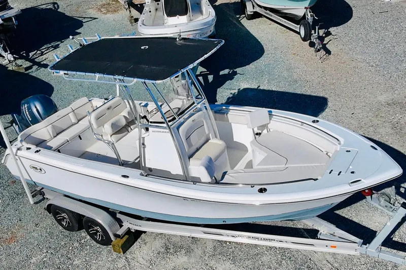 Slide: The Image of 2022 Sea Hunt Ultra 234 boat on trailer, featuring spacious seating and T-top canopy. - 9
