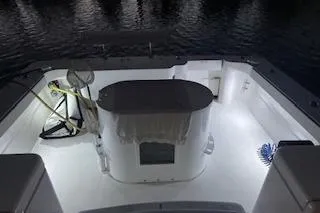 Slide: The Image of 2004 Luhrs 38 Open boat deck illuminated at night, showcasing fishing equipment. - 11