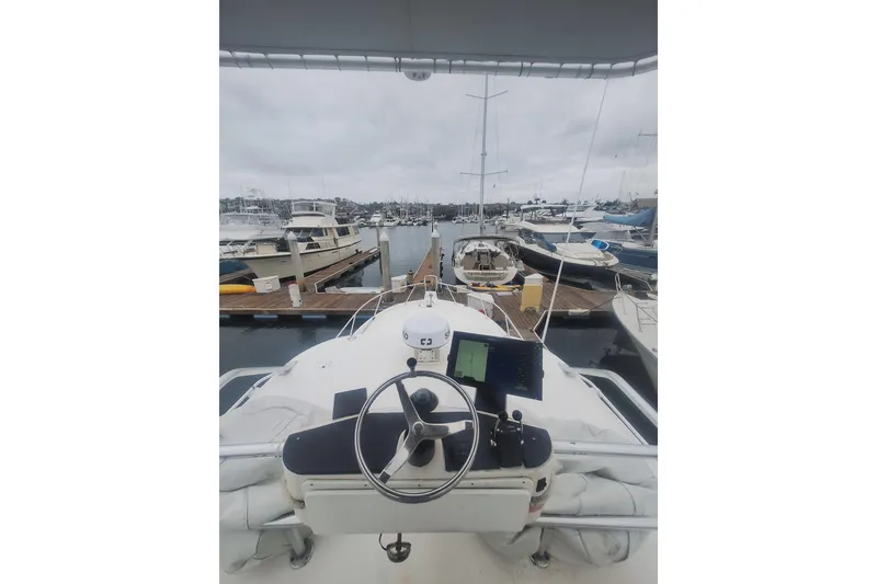 Slide: The Image of 2004 Luhrs 38 Open boat helm view at marina, surrounded by docked boats. - 13