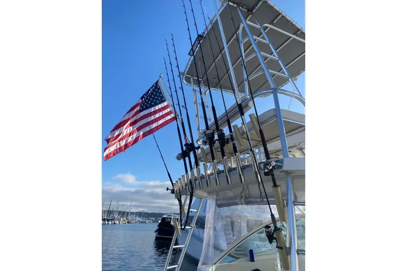 Slide: The Image of 2004 Luhrs 38 Open boat with fishing rods and American flag in marina. - 21