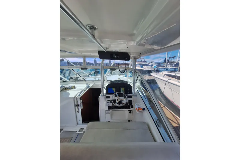 Slide: The Image of 2004 Luhrs 38 Open boat interior with helm, steering wheel, and marina view. - 28