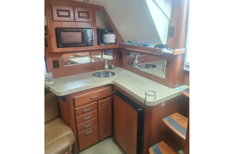 Slide: The Image of 2004 Luhrs 38 Open yacht interior kitchen with wooden cabinets and modern appliances. - 33