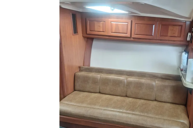 Slide: The Image of 2004 Luhrs 38 Open cabin interior with leather seating and wooden cabinetry. - 34