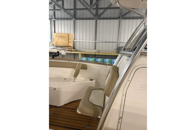 Slide: The Image of 2016 Key West 244 Center Console boat interior with beige seating in a metal shed. - 12