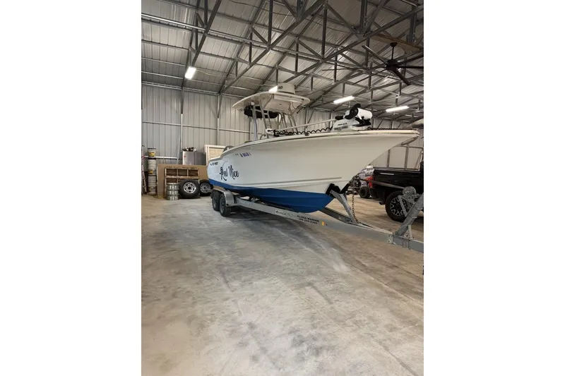 Slide: The Image of 2016 Key West 244 Center Console boat on trailer in a spacious indoor storage facility. - 2