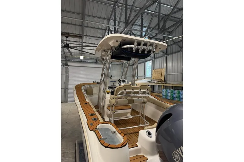 Slide: The Image of 2016 Key West 244 Center Console boat in a storage facility, featuring teak flooring and Yamaha engine. - 6