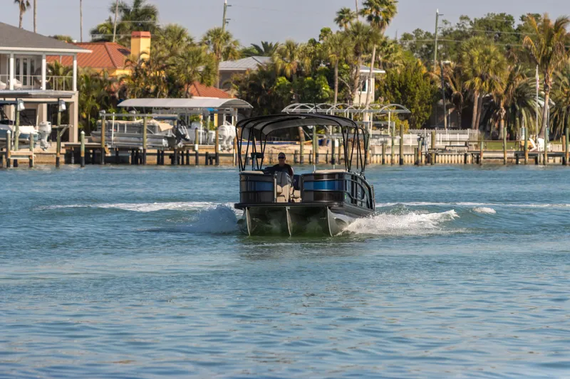 Slide: The Image of 2024 Barletta L23U pontoon boat cruising on a sunny waterfront. - 10