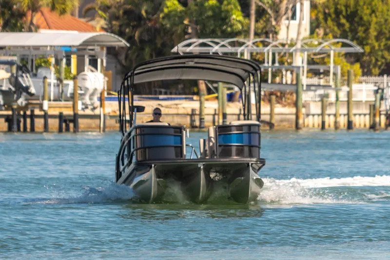 Slide: The Image of 2024 Barletta L23U pontoon boat cruising on a sunny waterfront. - 11