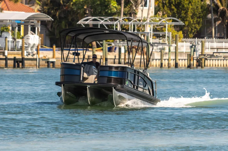 Slide: The Image of 2024 Barletta L23U pontoon boat cruising on a sunny waterway. - 12