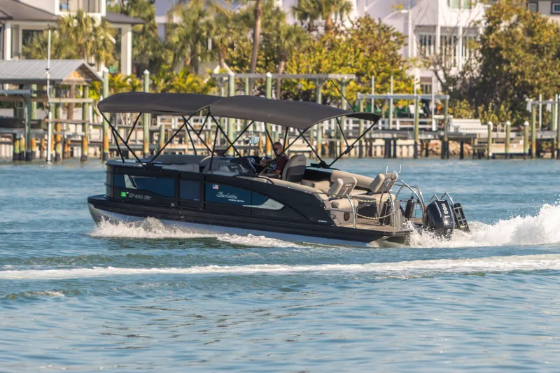 Slide: The Image of 2024 Barletta L23U pontoon boat cruising on a sunny waterfront. - 14