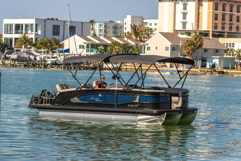 Slide: The Image of 2024 Barletta L23U pontoon boat cruising in a scenic marina setting. - 18