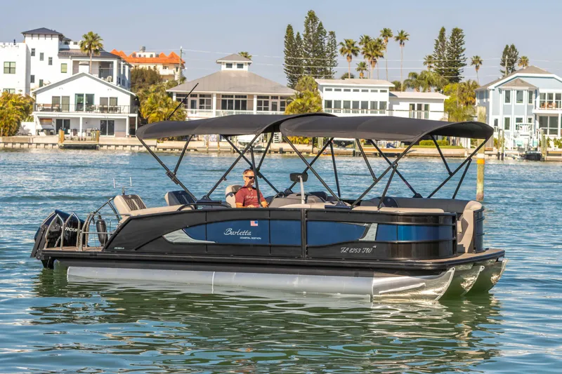 Slide: The Image of 2024 Barletta L23U pontoon boat cruising on a sunny waterfront. - 29