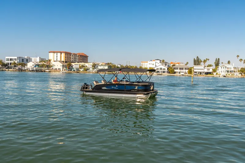 Slide: The Image of 2024 Barletta L23U pontoon boat cruising on a sunny waterfront. - 30