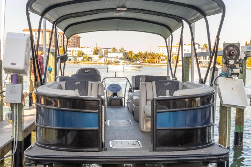 Slide: The Image of 2024 Barletta L23U pontoon boat docked, featuring spacious seating and canopy. - 31