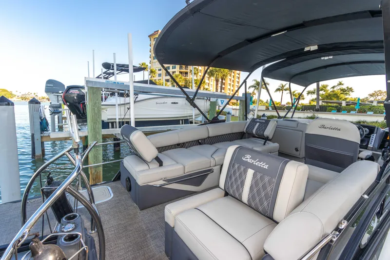 Slide: The Image of 2024 Barletta L23U pontoon boat with luxurious seating at a marina dock. - 39