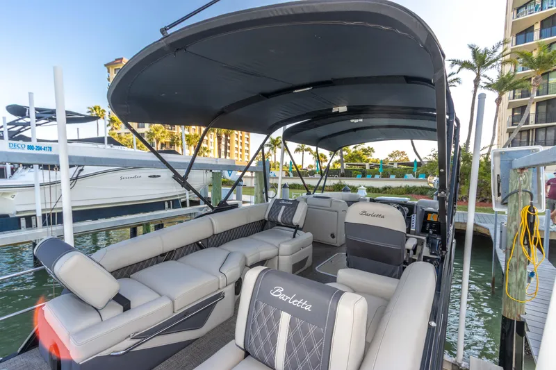 Slide: The Image of 2024 Barletta L23U pontoon boat with luxurious seating and canopy docked at marina. - 42