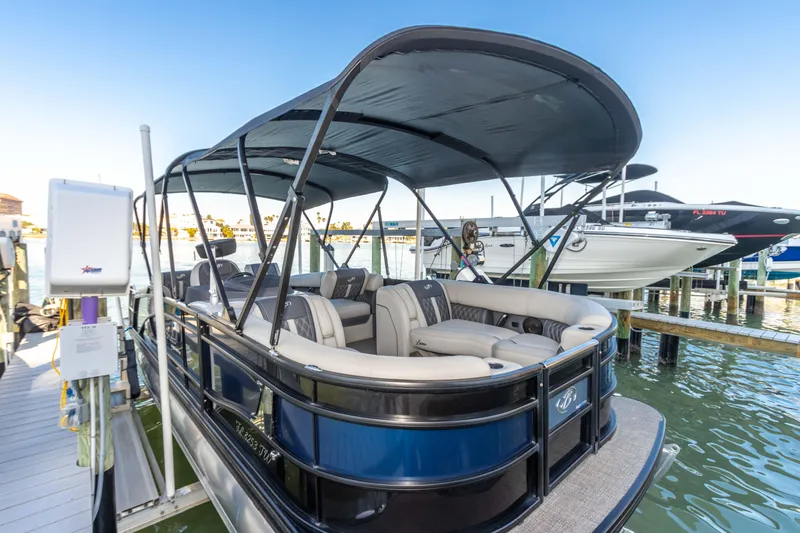 Slide: The Image of 2024 Barletta L23U pontoon boat docked, featuring spacious seating and canopy. - 43