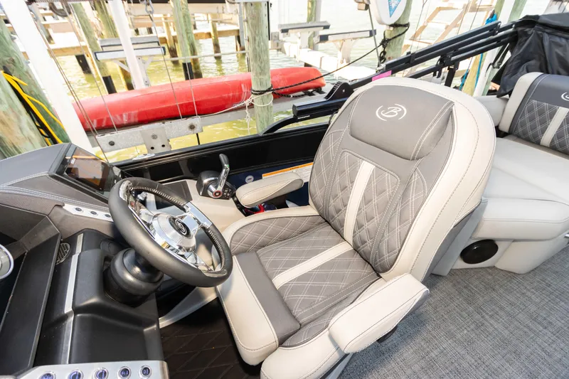Slide: The Image of 2024 Barletta L23U boat interior with luxurious captain's chair and steering wheel. - 46