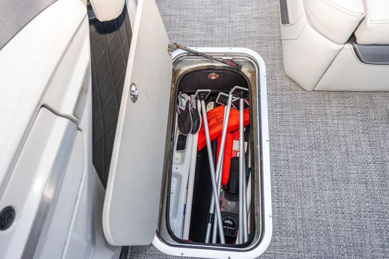 Slide: The Image of Open storage compartment on 2024 Barletta L23U boat with life jackets and equipment. - 52