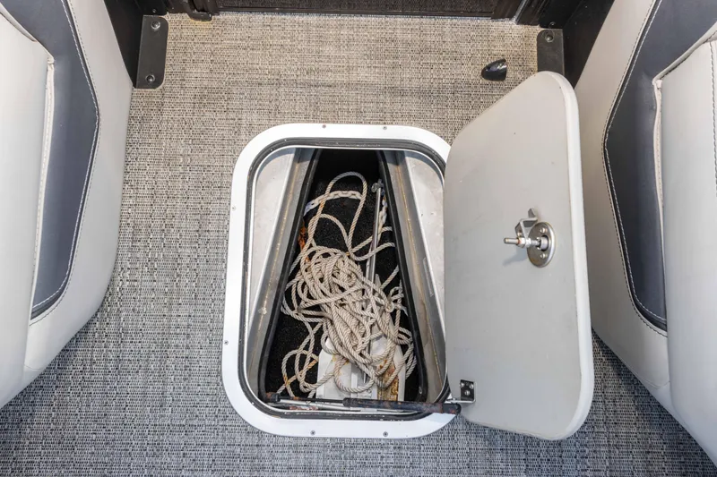Slide: The Image of 2024 Barletta L23U boat storage compartment with rope on textured flooring. - 55