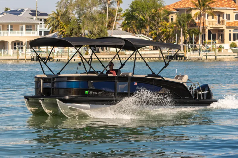 Slide: The Image of 2024 Barletta L23U pontoon boat cruising on a sunny waterfront. - 6