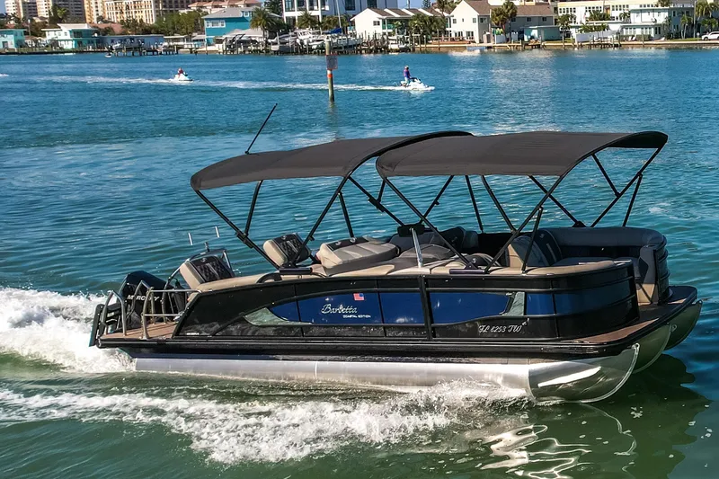 Slide: The Image of 2024 Barletta L23U pontoon boat cruising on a sunny waterfront. - 74