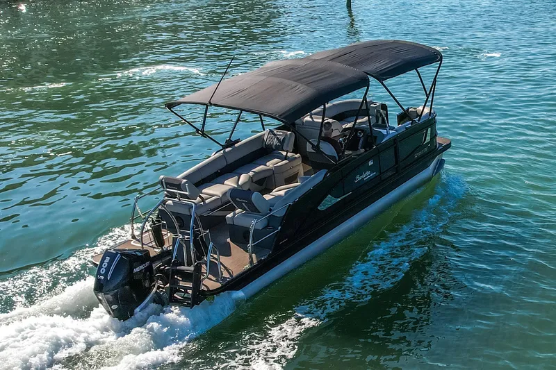 Slide: The Image of 2024 Barletta L23U pontoon boat cruising on clear blue water. - 76
