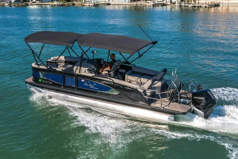 Slide: The Image of 2024 Barletta L23U pontoon boat cruising on clear blue water. - 77