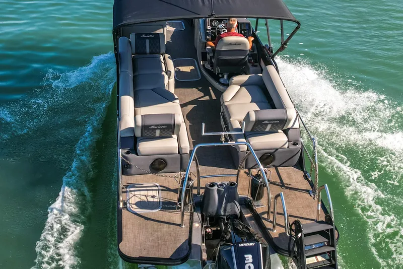 Slide: The Image of 2024 Barletta L23U pontoon boat cruising on clear water, showcasing spacious seating and sleek design. - 80