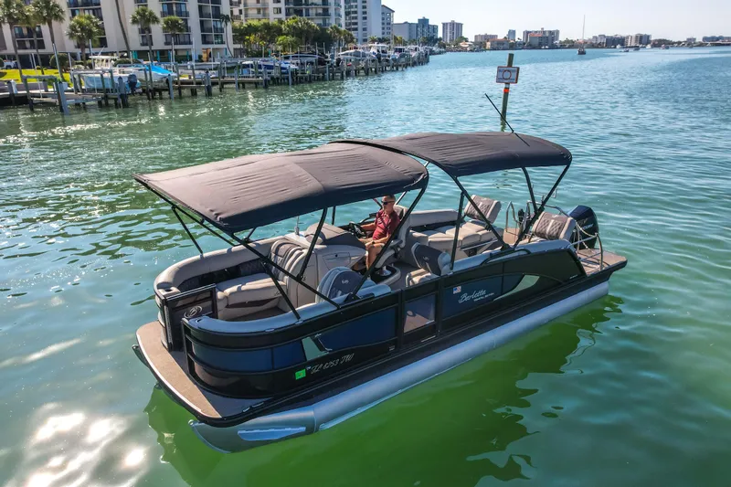Slide: The Image of 2024 Barletta L23U pontoon boat on calm water near a marina. - 84