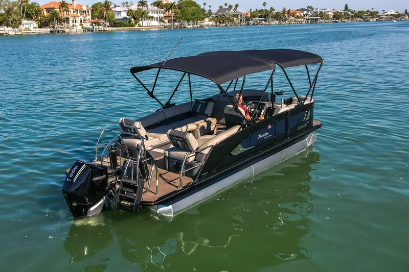 Slide: The Image of 2024 Barletta L23U pontoon boat cruising on a serene lake with luxurious seating. - 88