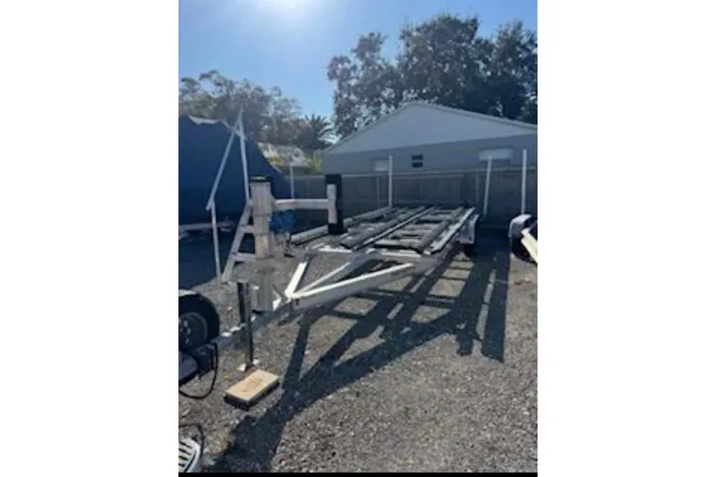 Slide: The Image of Trailer for 2024 Barletta L23U boat parked outdoors in sunny setting. - 92