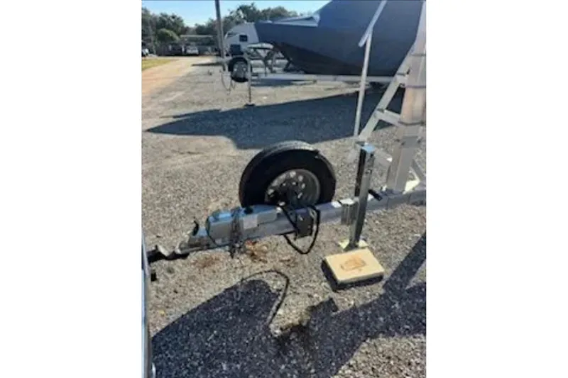 Slide: The Image of Trailer hitch and wheel of 2024 Barletta L23U boat in parking lot. - 93