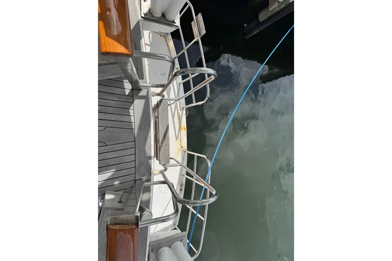 Slide: The Image of 1982 Custom Virpack Steel Hull boat deck with railing, docked by water. - 12