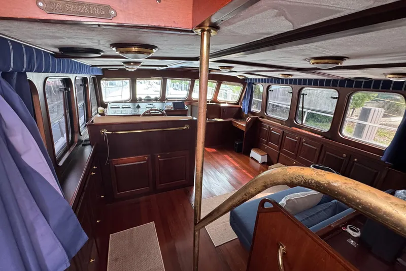 Slide: The Image of Interior of 1982 Custom Virpack Steel Hull boat with wood paneling and blue curtains. - 13