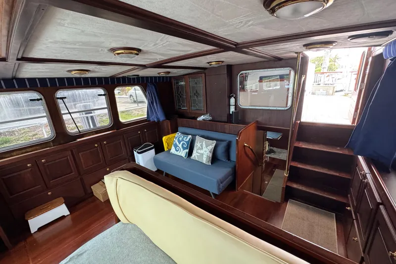 Slide: The Image of Interior of 1982 Custom Virpack Steel Hull boat with wooden furnishings and cozy seating area. - 16