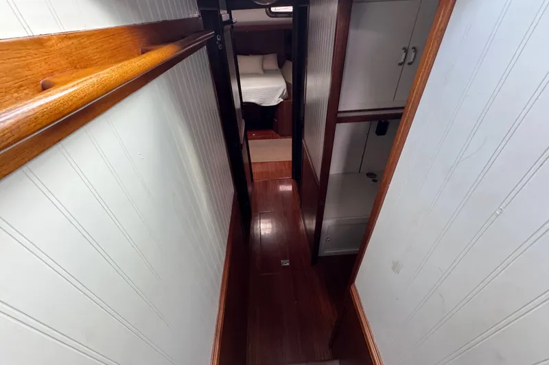 Slide: The Image of Narrow hallway inside 1982 Custom Virpack Steel Hull boat with wooden flooring and white walls. - 18