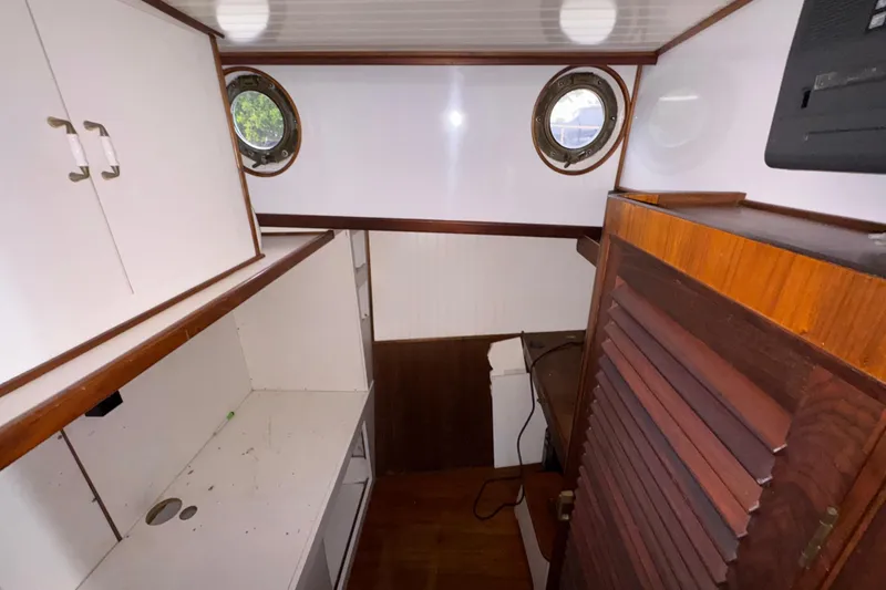 Slide: The Image of Interior of 1982 Custom Virpack Steel Hull boat with wooden cabinets and portholes. - 19