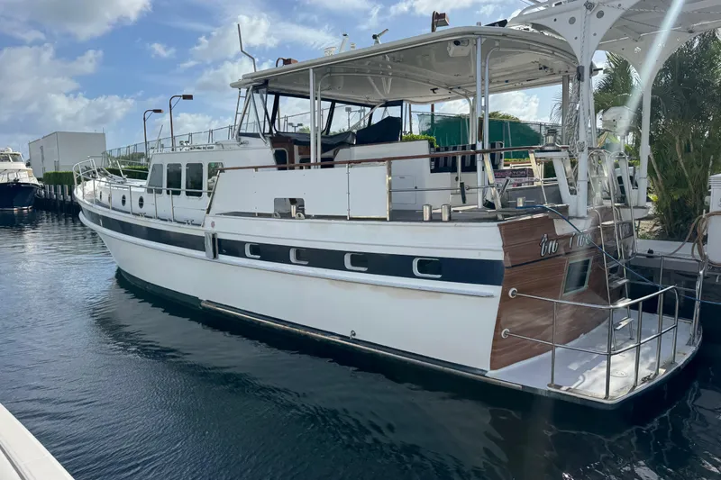 Slide: The Image of Custom 1982 Virpack Steel Hull yacht docked in a marina under a clear blue sky. - 2