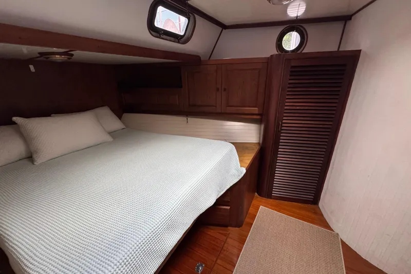 Slide: The Image of Cozy bedroom in 1982 Custom Virpack Steel Hull boat with wooden cabinetry and porthole windows. - 24