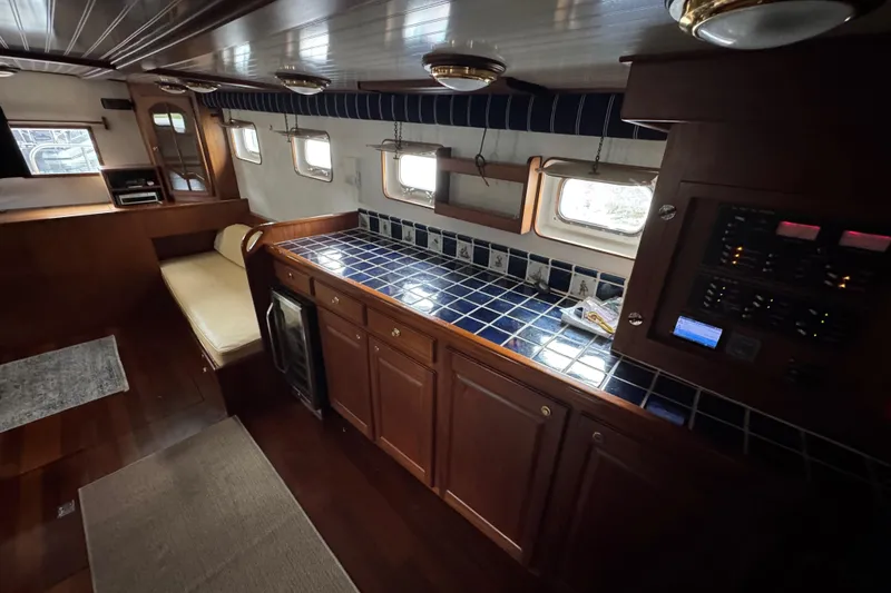 Slide: The Image of Interior of 1982 Custom Virpack Steel Hull yacht with blue-tiled countertop and wooden cabinetry. - 26