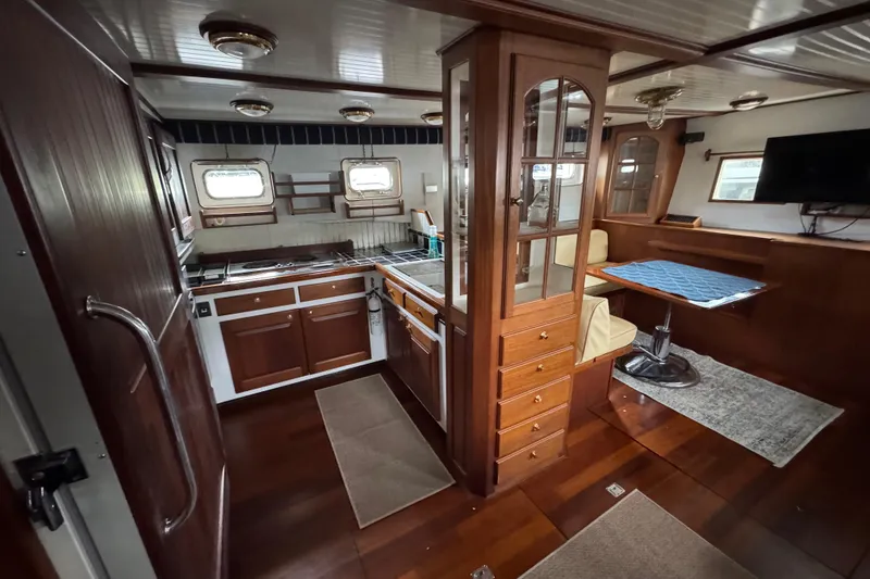 Slide: The Image of Interior of 1982 Custom Virpack Steel Hull yacht with wood cabinetry and dining area. - 27