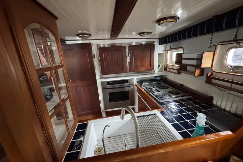 Slide: The Image of Vintage 1982 Custom Virpack Steel Hull yacht kitchen with wooden cabinets and tiled countertops. - 30