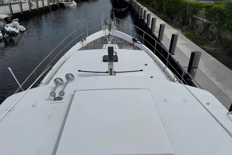 Slide: The Image of 1982 Custom Virpack Steel Hull boat docked in a canal, featuring a spacious deck. - 6