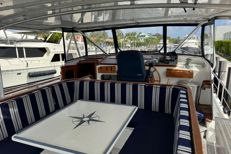 Slide: The Image of Interior of 1982 Custom Virpack Steel Hull boat with striped seating and nautical-themed table. - 9
