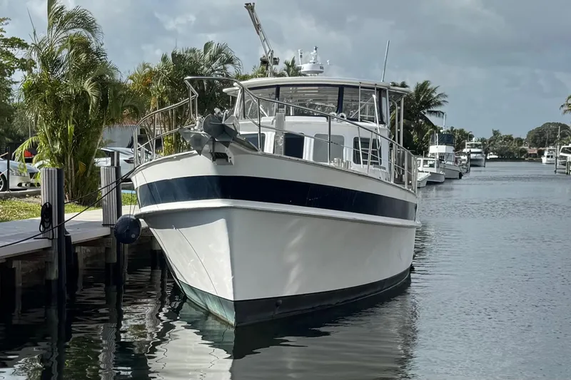 Slide: The Image of 1982 Custom Virpack Steel Hull boat docked on a calm waterway, surrounded by palm trees. - 1